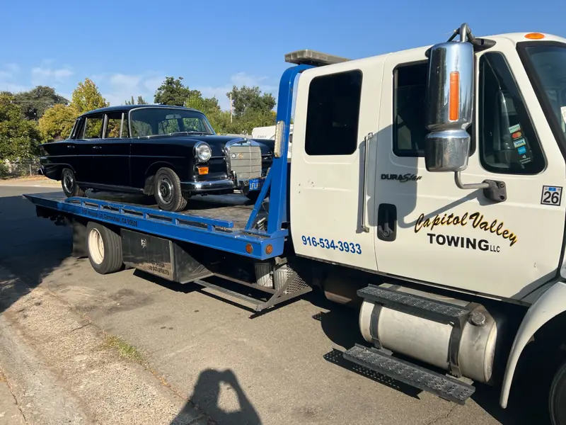 Black vintage sedan on a flatbed