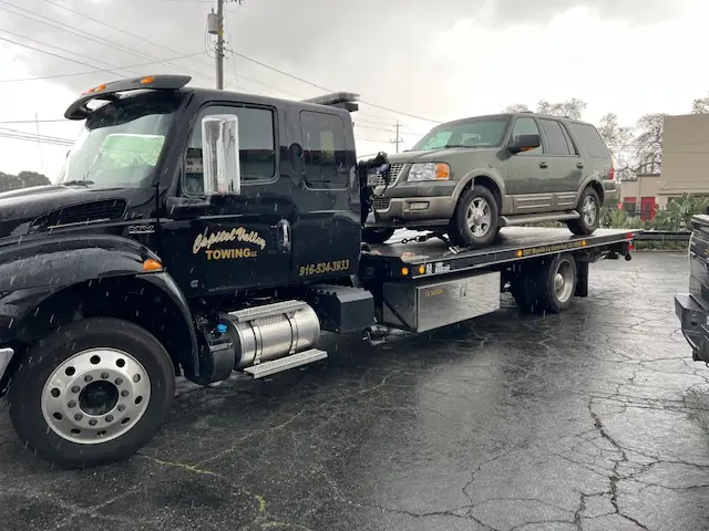 Capitol Valley Towing truck carrying an SUV
