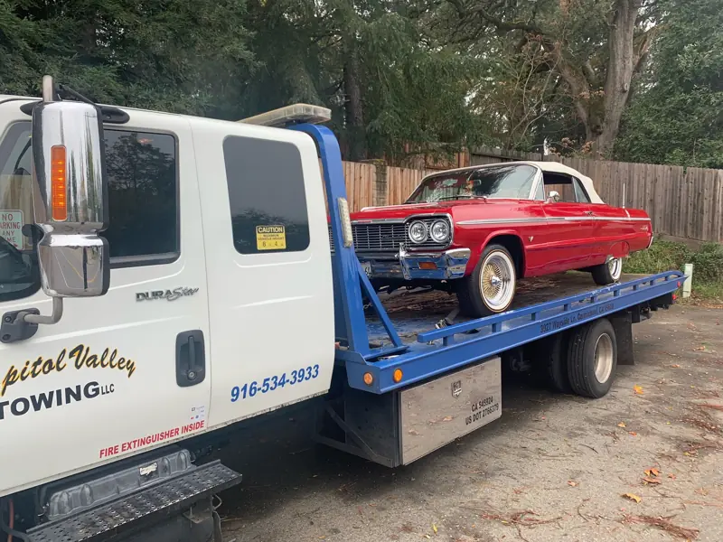 Red Impala convertible on a flatbed