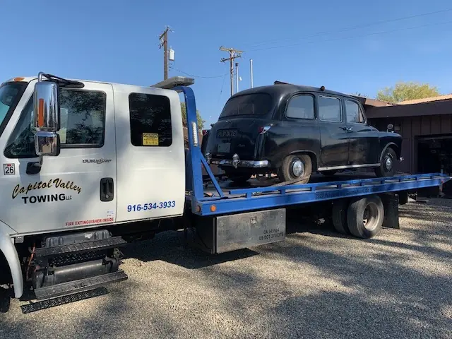 Black London taxi on a flatbed